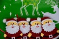 Four Santa Claus figures on a Christmas green background