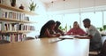 Four schoolmates talking sit at table in college library