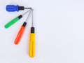 Four screwdrivers of different sizes with blue, green, red and yellow handles on the light textile background Royalty Free Stock Photo