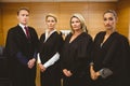 Four serious judges standing while wearing robes