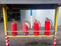 Four sets of red-colored fire extinguishers are placed at the boiler station to be prepared for an upcoming fire.