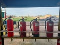 Four sets of red-colored fire extinguishers are placed at the boiler station to be prepared for an upcoming fire.