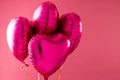 Four shiny pink heart shaped balloons floating on pink background with copy space