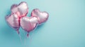 Four shiny pink heart shaped balloons floating on a blue background with copy space. Pink helium balloons in the shape