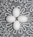 Four simple white eggs lie on a Lacy background. On a white lace napkin are pure white eggs. Group of white eggs. Composition of e Royalty Free Stock Photo