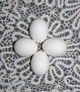 Four simple white eggs lie on a Lacy background. On a white lace napkin are pure white eggs. Group of white eggs. Composition of e