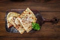 Four sliced wedges of meat and veggie filled quesadillas on cutting board.