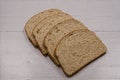 Four slices of brown oatmeal bread lying on a wooden board