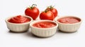 Photo of four small bowls of tomato sauce with tomatoes in the background