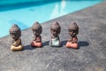 four small buddha statues in calm different rest pose.