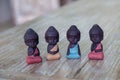 four small buddha statues in calm different rest pose.