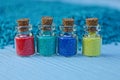 Four small glass bottles with colored sand