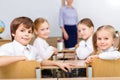 Four smiling pupils sitting at the desk