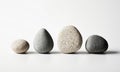 Four smooth stones arranged in a row on a white background Royalty Free Stock Photo