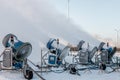 Four snow cannons spray artificial ice crystals.