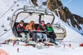 Four snowboard riders making fun on a chair lift