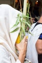 Sukkot. Man holding a lulav and etrog in synagogue