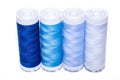 Four spools of thread shades of blue on a white background. Royalty Free Stock Photo