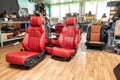 Four sport seats with red leather trim, located on the floor in the workshop for repair and tuning