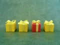 Four square red and yellow gift boxes neatly placed on green textured background. Royalty Free Stock Photo