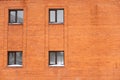 Four square windows on the facade of a red kitpich house, brick background Royalty Free Stock Photo