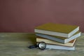 Four stamp albums books bunch, loupe and tweezers on wooden table and bordeaux background. Royalty Free Stock Photo