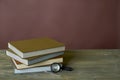 Four stamp albums books bunch, loupe and tweezers on wooden table and bordeaux background Royalty Free Stock Photo