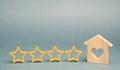 Four stars and a wooden house on a gray background. Success. Feedback. Good evaluation of the critic. Hotel rating. Quality of Royalty Free Stock Photo