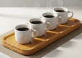 Four steaming coffee mugs are arranged linearly on a rectangular Royalty Free Stock Photo
