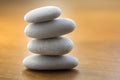 Stone cairn tower, poise stones, rock zen sculpture, light white pebbles on wooden background