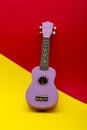Four string ukulele guitar on red and yellow background