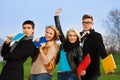 Four students with books cheering