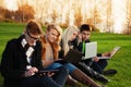 Four students working on laptops in the park