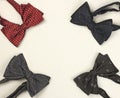 Four stylish bow ties on cardboard background with copy space, postcard for congratulatory texts or invitations, top view, closeup