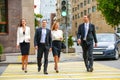 Four successful business people crossing the street in the city Royalty Free Stock Photo