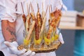Four tasty grilled pork sausages from a BBQ served with a mustard dip on an old wooden cutting board in a close up view Royalty Free Stock Photo
