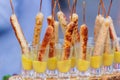 Four tasty grilled pork sausages from a BBQ served with a mustard dip on an old wooden cutting board in a close up view Royalty Free Stock Photo