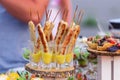 Four tasty grilled pork sausages from a BBQ served with a mustard dip on an old wooden cutting board in a close up view Royalty Free Stock Photo