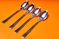 Four teaspoons laid out on an orange background Royalty Free Stock Photo