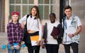 Four teenagers with folders and backpacks