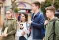 Four teenagers talking about play on walk in street