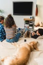 four teens watching tv and dog lying