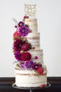Four Tiered Wedding Cake With Fresh Flowrs Wrapped around it