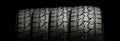 Four tires in a row for SUVs and crossovers with powerful checkers and ground grabs close-up on a black background