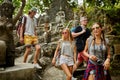 Four tourists walking through ancient jungle ruins in thailand