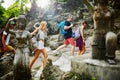 Four tourists walking through ancient jungle ruins in thailand