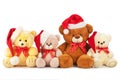 Four toy teddy bears wearing santa hats sit in a row. Isolated on white background Royalty Free Stock Photo