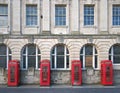 Four traditional british red phone boxes outside an old post office building in blackpool england Royalty Free Stock Photo