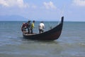 Four traditional fishermen on Alue Naga Beach, Banda Aceh, Indonesia, are working on a boat to operate a beach seine-type trawl be