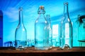 Four transparent glass bottles on a barn wood table in front of a blue background Royalty Free Stock Photo